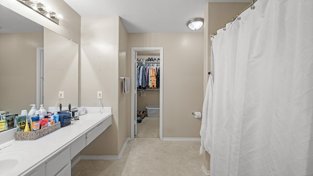 bathroom featuring tile patterned floors, vanity, and a textured ceiling