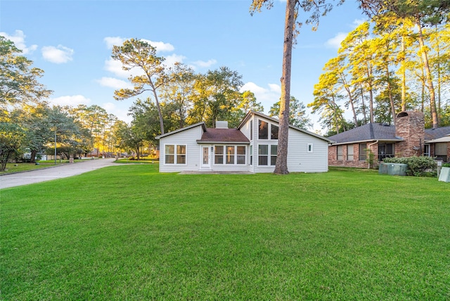 rear view of property with a yard