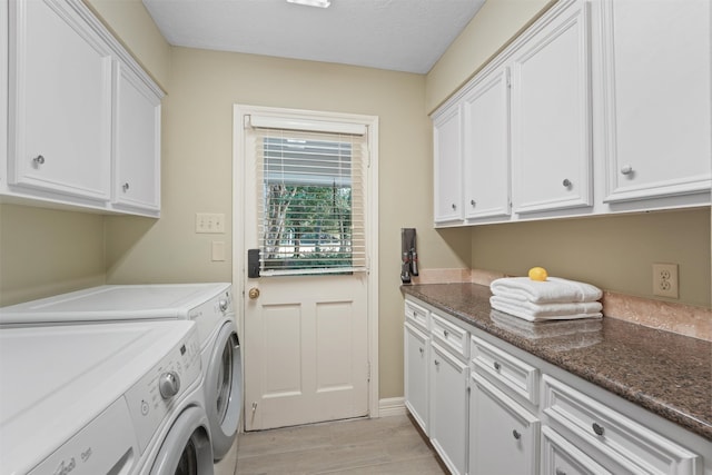 clothes washing area with cabinets, light hardwood / wood-style flooring, washer and dryer, and a textured ceiling