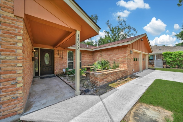 property entrance featuring cooling unit and a garage