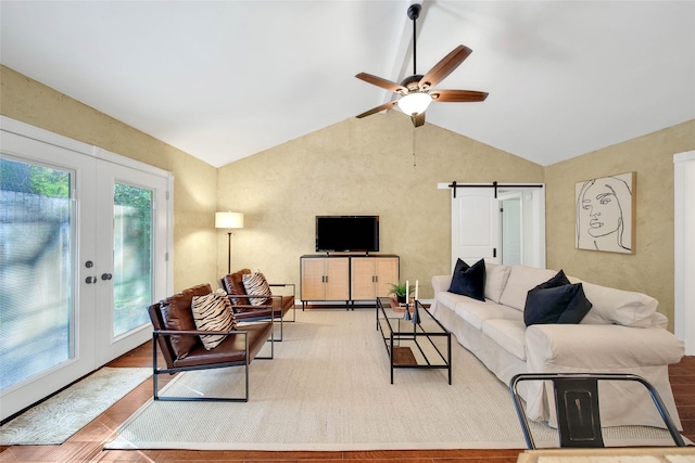 living room featuring hardwood / wood-style floors, a barn door, a healthy amount of sunlight, and french doors