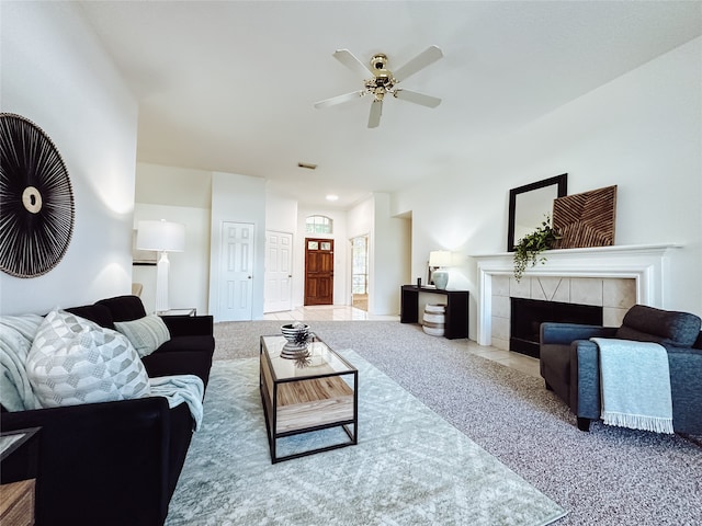 living room featuring a fireplace, carpet floors, and ceiling fan