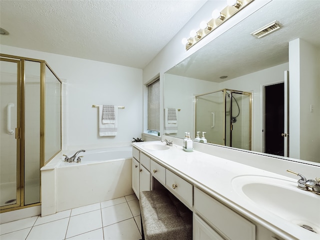 bathroom featuring vanity, tile patterned flooring, plus walk in shower, and a textured ceiling