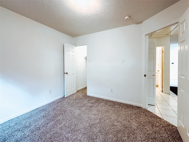 carpeted empty room with a textured ceiling