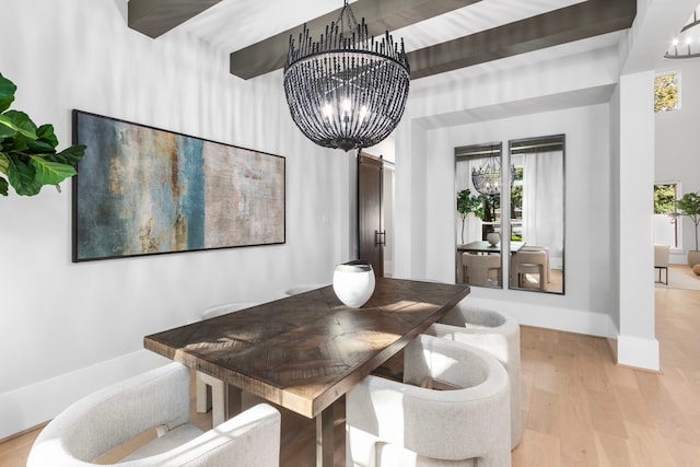 dining room with baseboards, a barn door, wood finished floors, and a notable chandelier