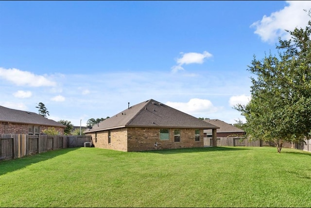 rear view of house featuring a yard