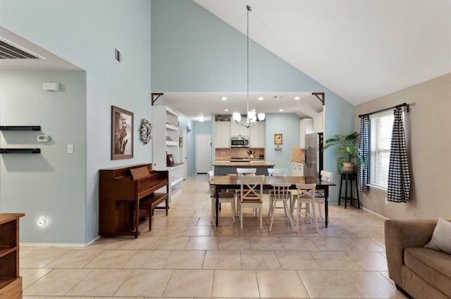 tiled dining space with built in shelves, high vaulted ceiling, and a notable chandelier