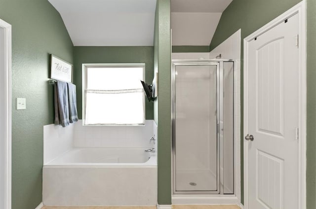 bathroom featuring vaulted ceiling and independent shower and bath