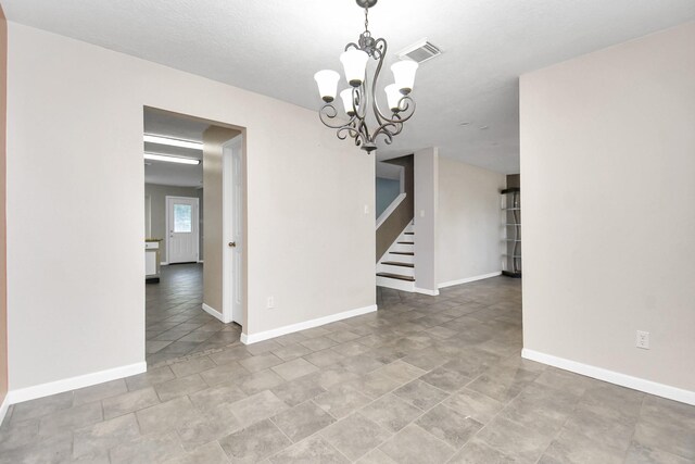 spare room with a notable chandelier