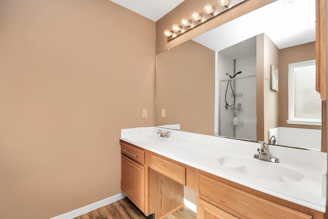 bathroom featuring hardwood / wood-style flooring, vanity, and a shower