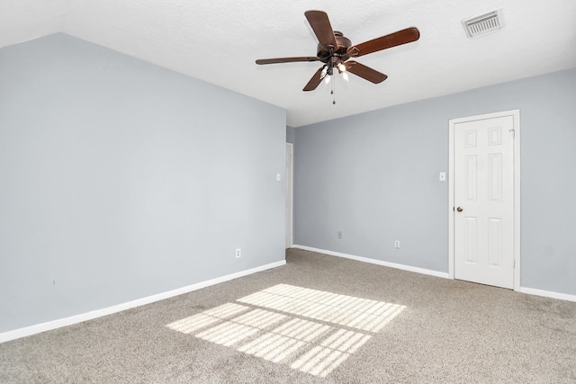 carpeted empty room with a textured ceiling, ceiling fan, and vaulted ceiling