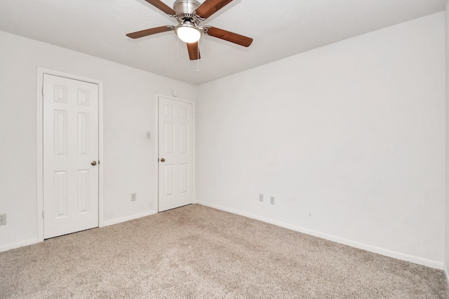 carpeted spare room with ceiling fan