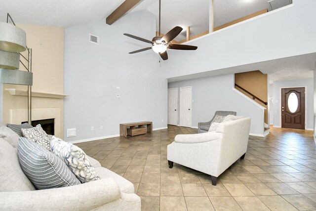 living room with tile patterned floors, ceiling fan, beamed ceiling, and high vaulted ceiling