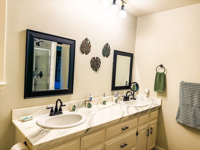 bathroom with a textured ceiling, vanity, and a shower with door