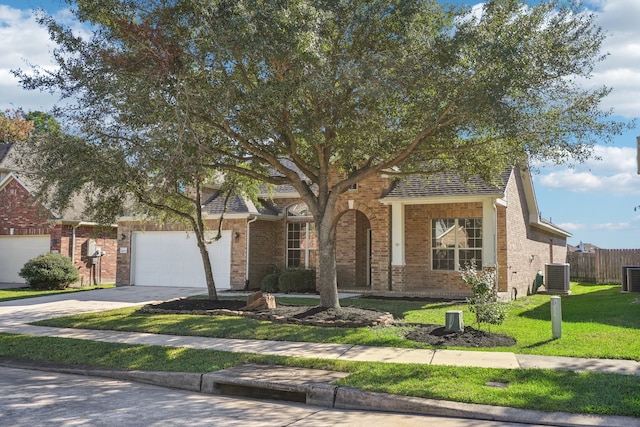 view of front of home featuring a front yard, a garage, and central AC unit