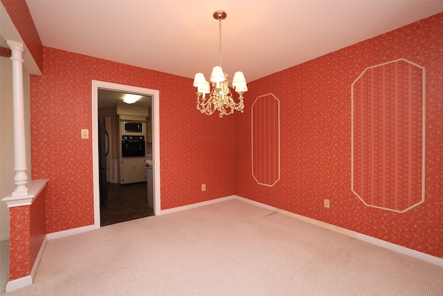 empty room featuring carpet, a chandelier, and ornate columns