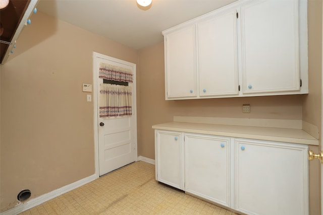 clothes washing area featuring cabinets