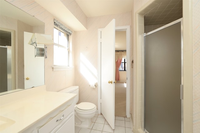 bathroom featuring tile patterned flooring, vanity, toilet, and walk in shower