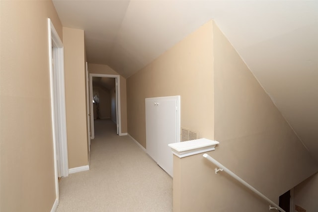 corridor featuring lofted ceiling and light carpet