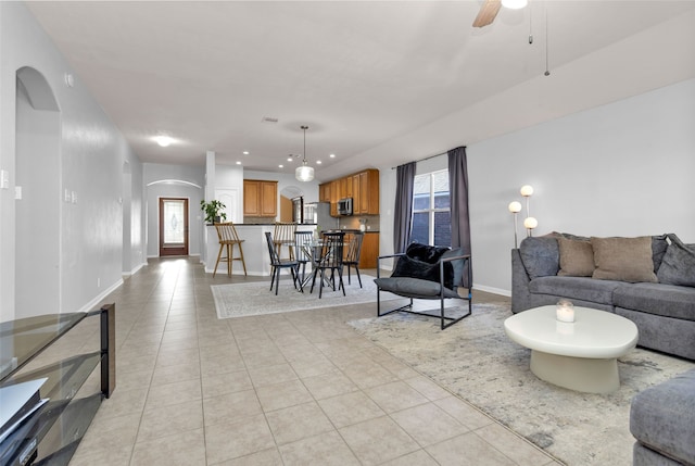 tiled living room with ceiling fan