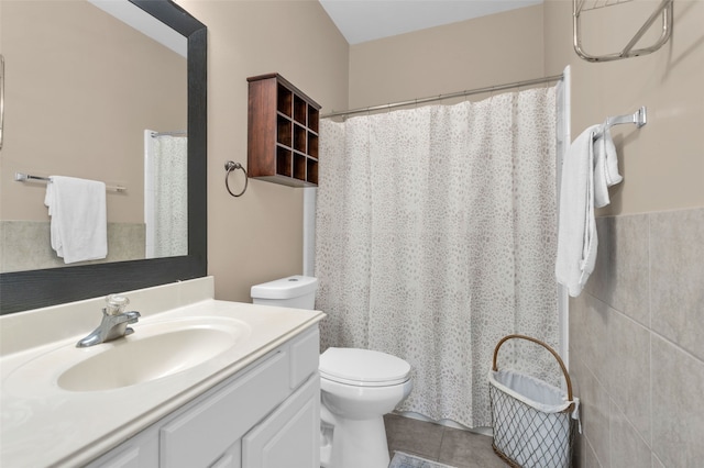 bathroom featuring tile patterned flooring, vanity, toilet, and tile walls