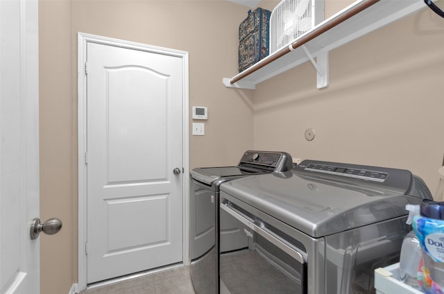 laundry area with light tile patterned floors and washing machine and clothes dryer