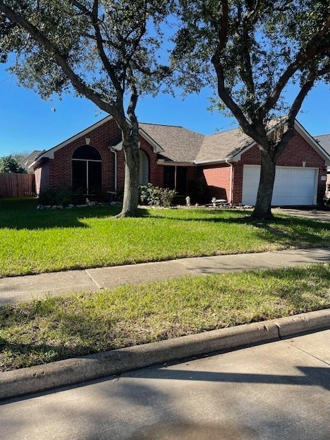 ranch-style house featuring a front yard and a garage