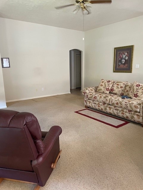 carpeted living room with ceiling fan