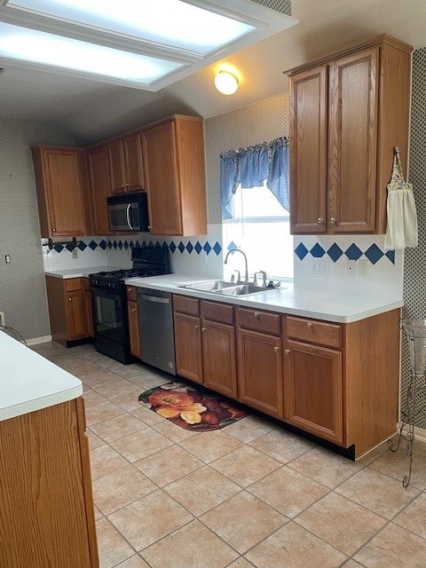 kitchen featuring appliances with stainless steel finishes, tasteful backsplash, light tile patterned floors, and sink