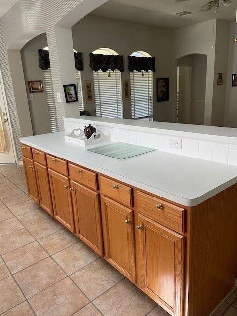 kitchen featuring ceiling fan, a kitchen island, and light tile patterned floors