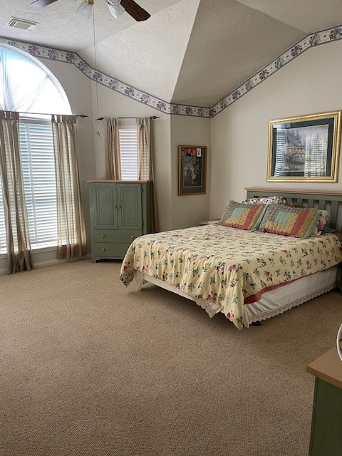 carpeted bedroom with a textured ceiling, ceiling fan, and lofted ceiling