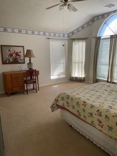 carpeted bedroom featuring a textured ceiling, ceiling fan, and vaulted ceiling