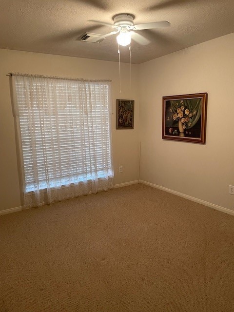 carpeted empty room featuring a textured ceiling and ceiling fan