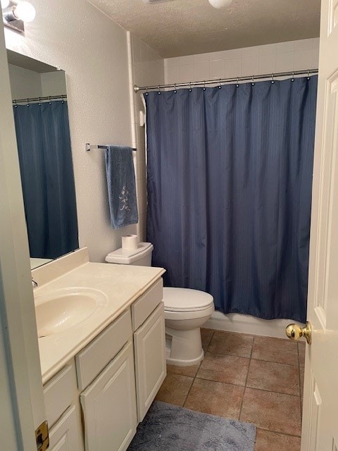 full bathroom with vanity, a textured ceiling, shower / bathtub combination with curtain, tile patterned flooring, and toilet