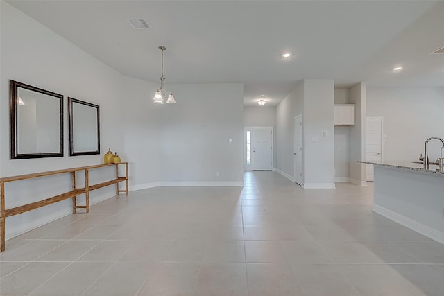 spare room with an inviting chandelier, light tile patterned flooring, and sink