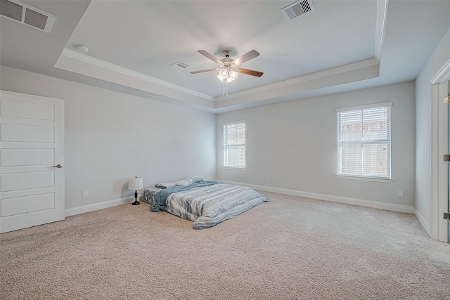 bedroom featuring ceiling fan, light carpet, ornamental molding, and a raised ceiling