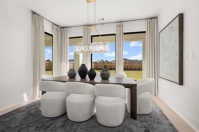 dining space featuring hardwood / wood-style floors and a notable chandelier