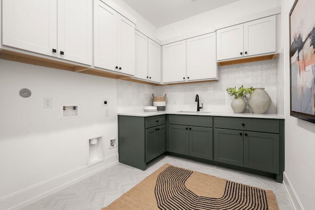 clothes washing area featuring electric dryer hookup, cabinets, light parquet floors, sink, and washer hookup