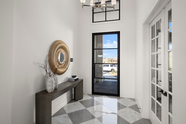 foyer entrance with french doors and a chandelier