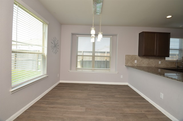 unfurnished dining area with a chandelier, dark hardwood / wood-style flooring, plenty of natural light, and sink