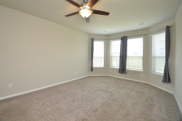 carpeted spare room featuring ceiling fan