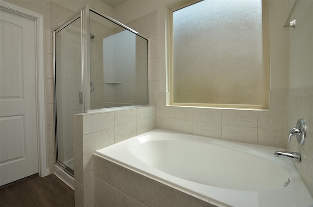 bathroom with independent shower and bath and wood-type flooring