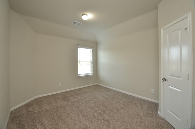 empty room with light colored carpet and lofted ceiling