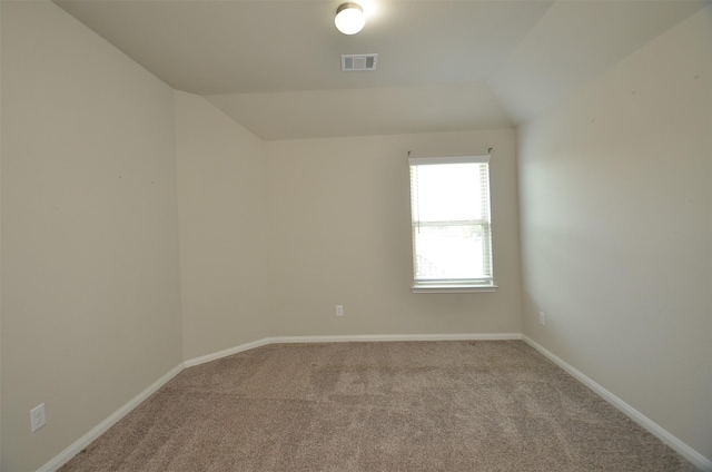 carpeted empty room with lofted ceiling