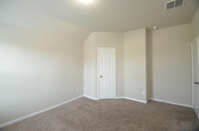 carpeted empty room with lofted ceiling