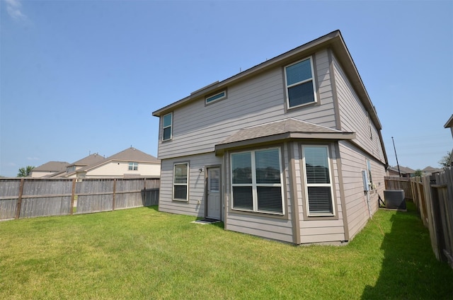 back of property with a lawn and central AC unit