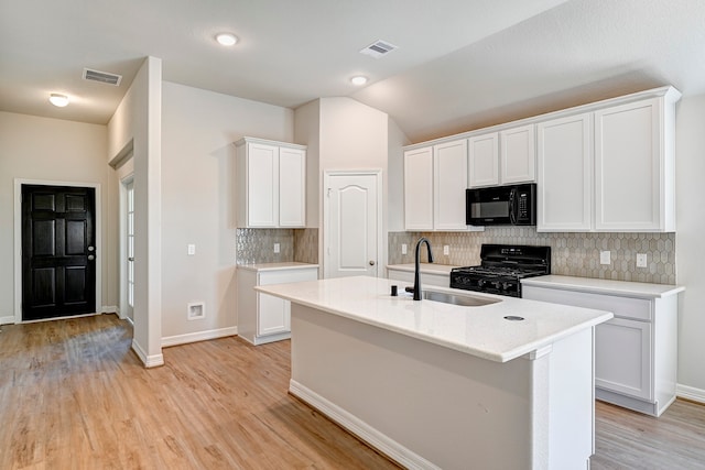 kitchen with white cabinets, decorative backsplash, vaulted ceiling, and black appliances