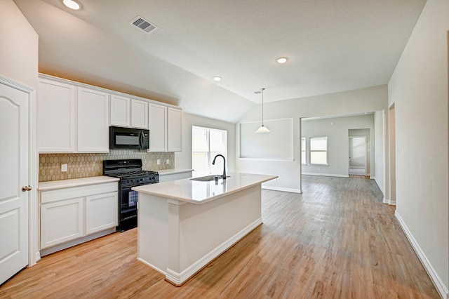 kitchen with backsplash, white cabinetry, vaulted ceiling, and black appliances