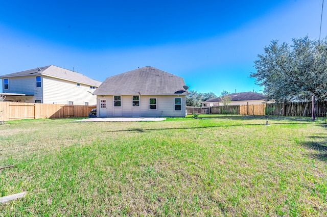 back of property with a yard and a patio