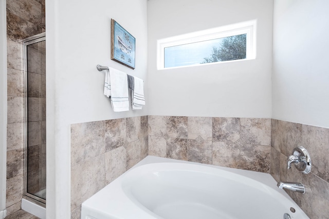 bathroom featuring shower with separate bathtub